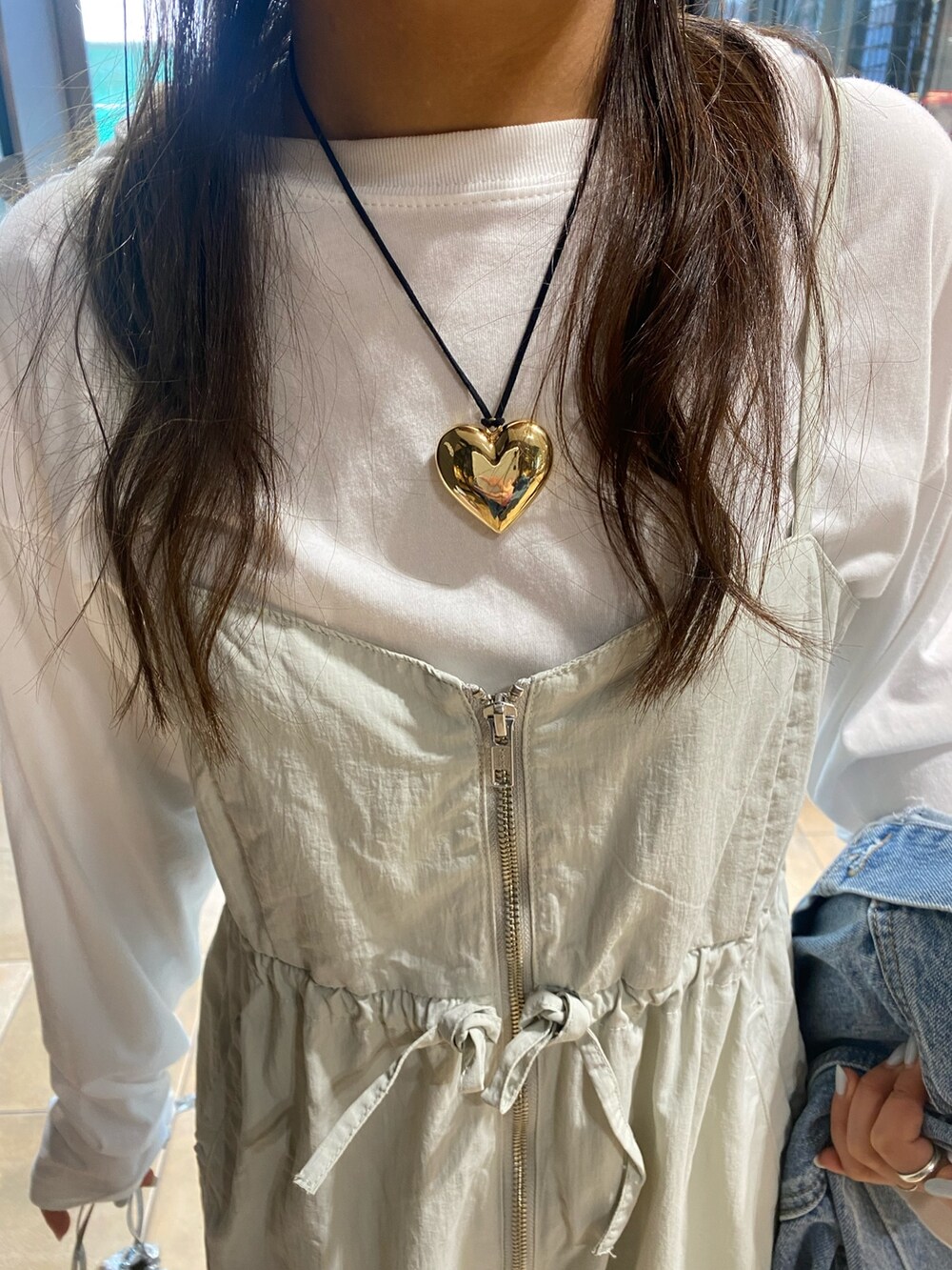 ブルー系のデニムジャケット、グレー系のサロペット/オーバーオール、ゴールド系のネックレスを着用したレディースの冬コーディネートの6枚目の写真