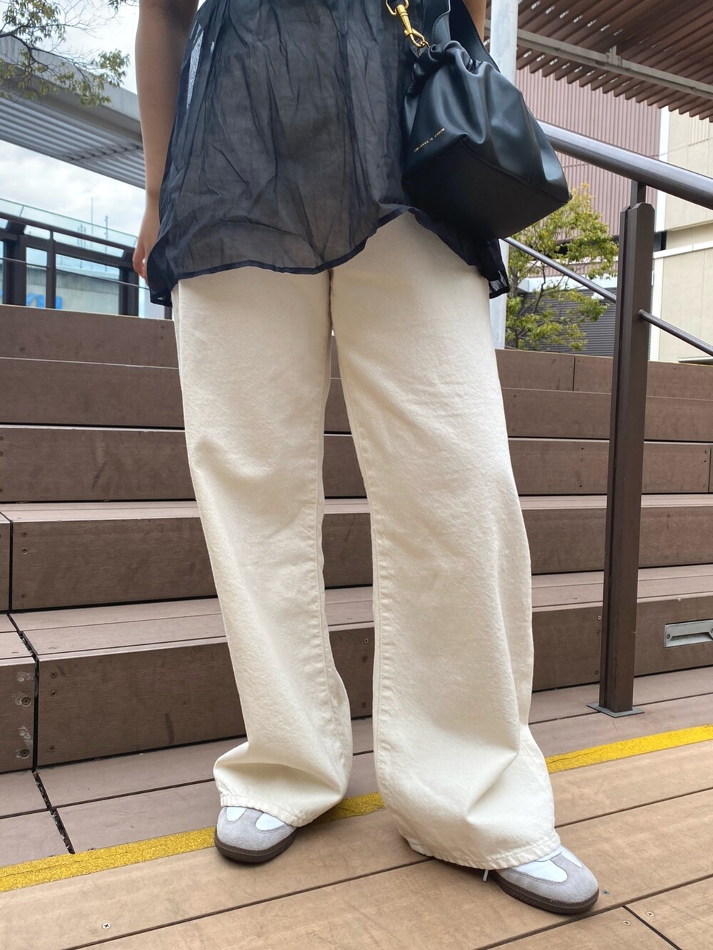 ホワイト系のTシャツ/カットソー、ブラック系のキャミソール、ホワイト系のデニムパンツを着用したレディースの春コーディネートの6枚目の写真