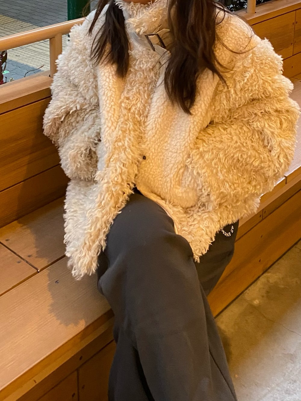 ホワイト系のムートンコート、グレー系のスウェットパンツを着用したレディースの冬コーディネートの6枚目の写真