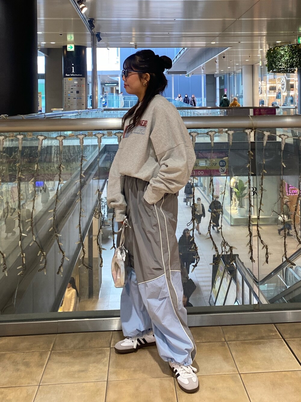 グレー系のスウェット、ブルー系のその他パンツ、ブラック系のサングラスを着用したレディースの冬コーディネートの2枚目の写真