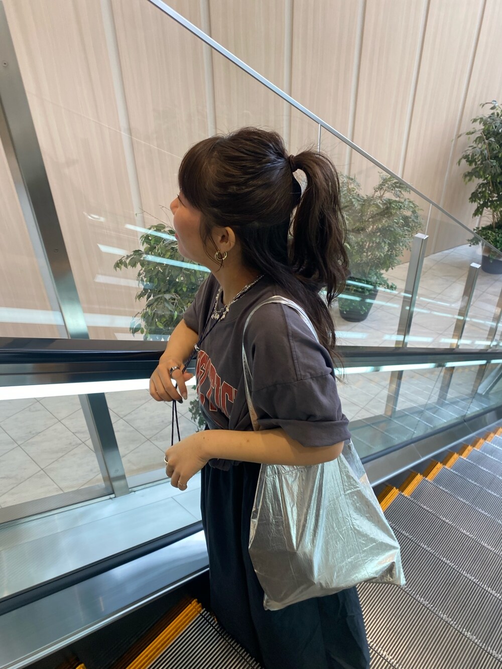 グレー系のTシャツ/カットソー、ブラック系のワンピースを着用したレディースの春コーディネートの6枚目の写真