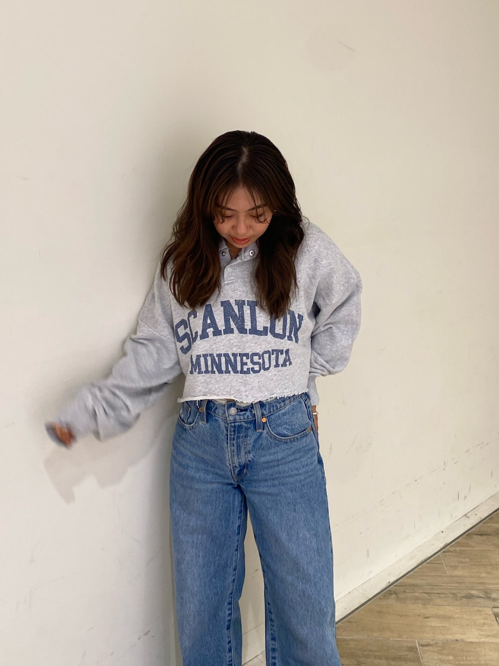 グレー系のパーカー、ブルー系のデニムパンツを着用したレディースの秋コーディネートの4枚目の写真