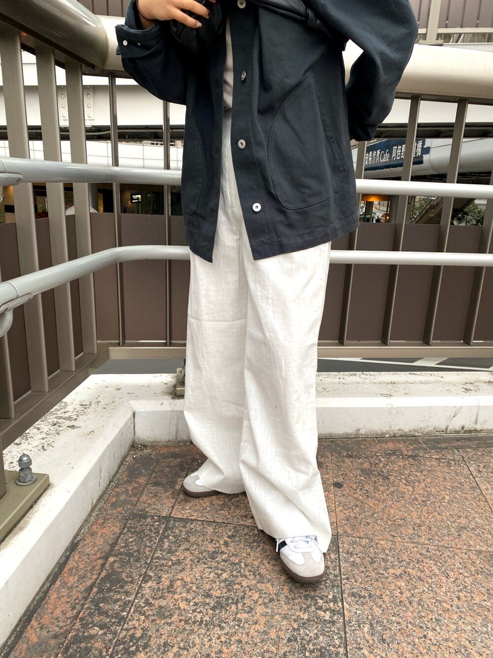 グレー系のブルゾン、ホワイト系のその他パンツ、ホワイト系のキャミソールを着用したレディースの春コーディネートの6枚目の写真