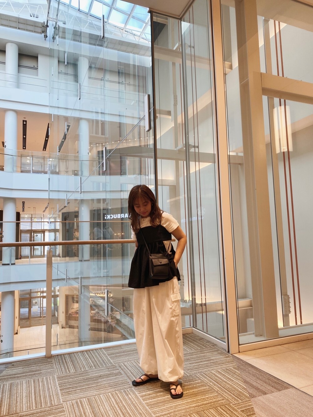 ブラック系のキャミソール、ホワイト系のカーゴパンツ、ホワイト系のTシャツ/カットソーを着用したレディースの夏コーディネートの2枚目の写真