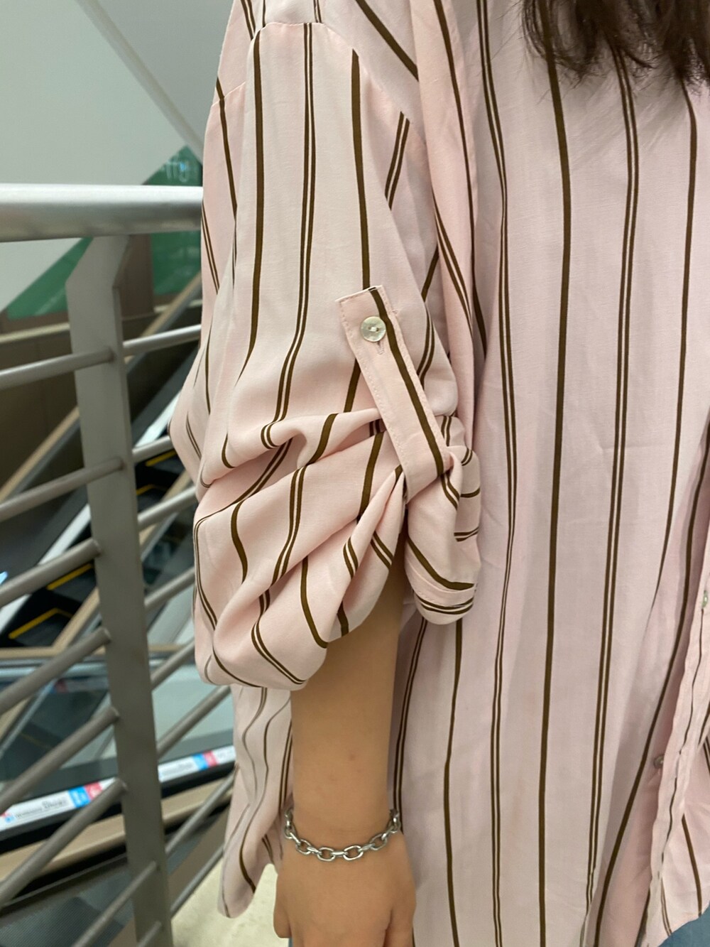 ピンク系のシャツ/ブラウス、ブルー系のデニムパンツ、シルバー系のショルダーバッグを着用したレディースの冬コーディネートの3枚目の写真