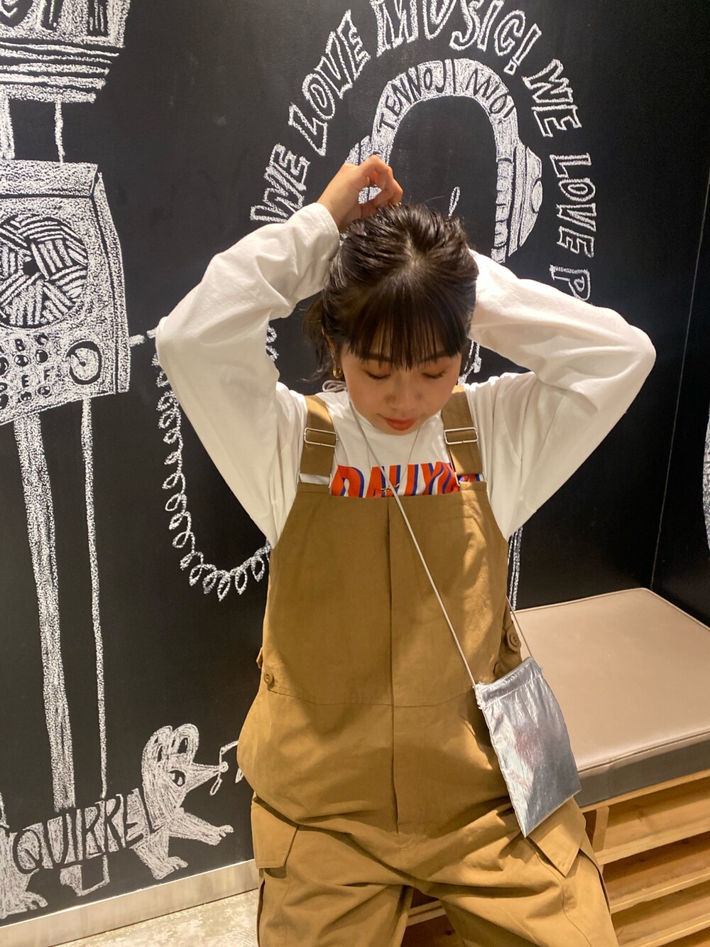 イエロー系のつなぎ/オールインワン、ホワイト系のTシャツ/カットソー、シルバー系のショルダーバッグを着用したレディースの冬コーディネートの5枚目の写真