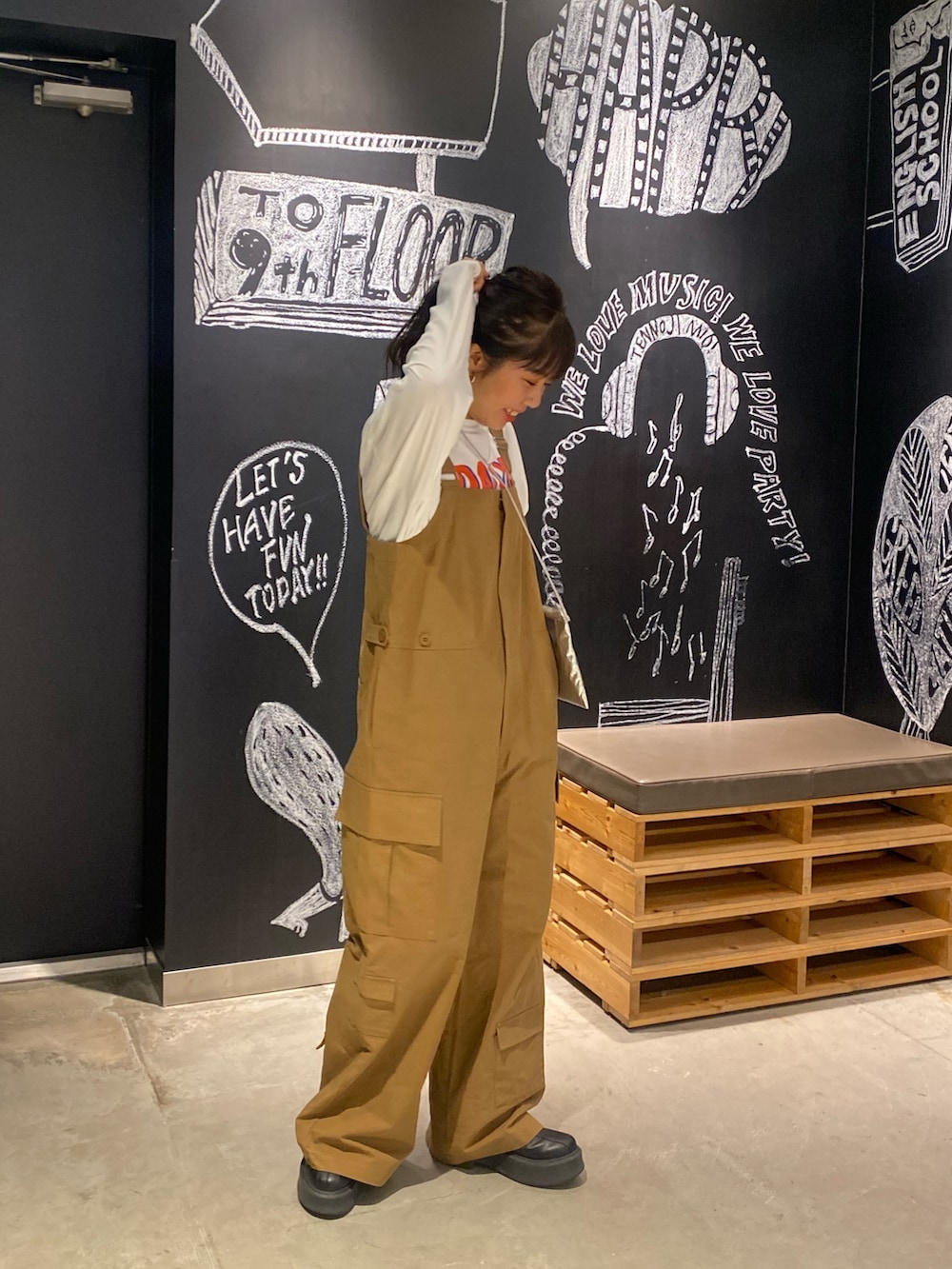 イエロー系のつなぎ/オールインワン、ホワイト系のTシャツ/カットソー、シルバー系のショルダーバッグを着用したレディースの冬コーディネートの3枚目の写真