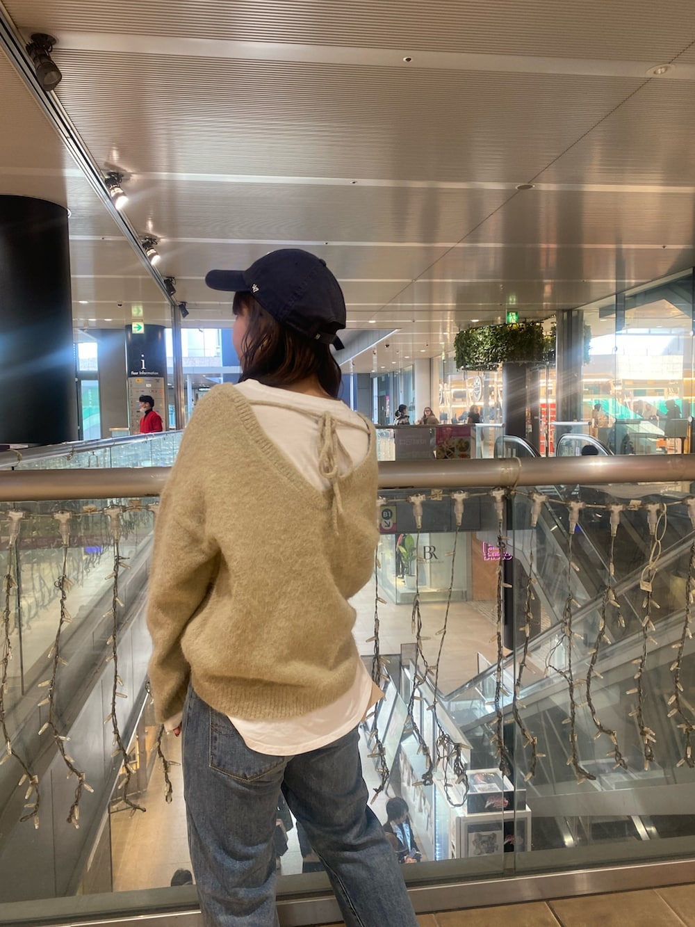 グレー系のニット/セーター、ブルー系のデニムパンツを着用したレディースの冬コーディネートの5枚目の写真