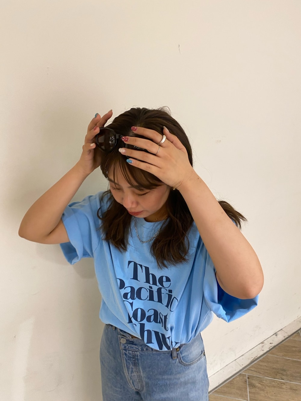 ブルー系のTシャツ/カットソー、ブルー系のデニムパンツ、ブラック系のサンダルを着用したレディースの春コーディネートの5枚目の写真