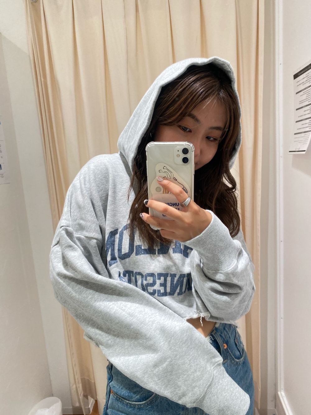 グレー系のパーカー、ブルー系のデニムパンツを着用したレディースの秋コーディネートの6枚目の写真