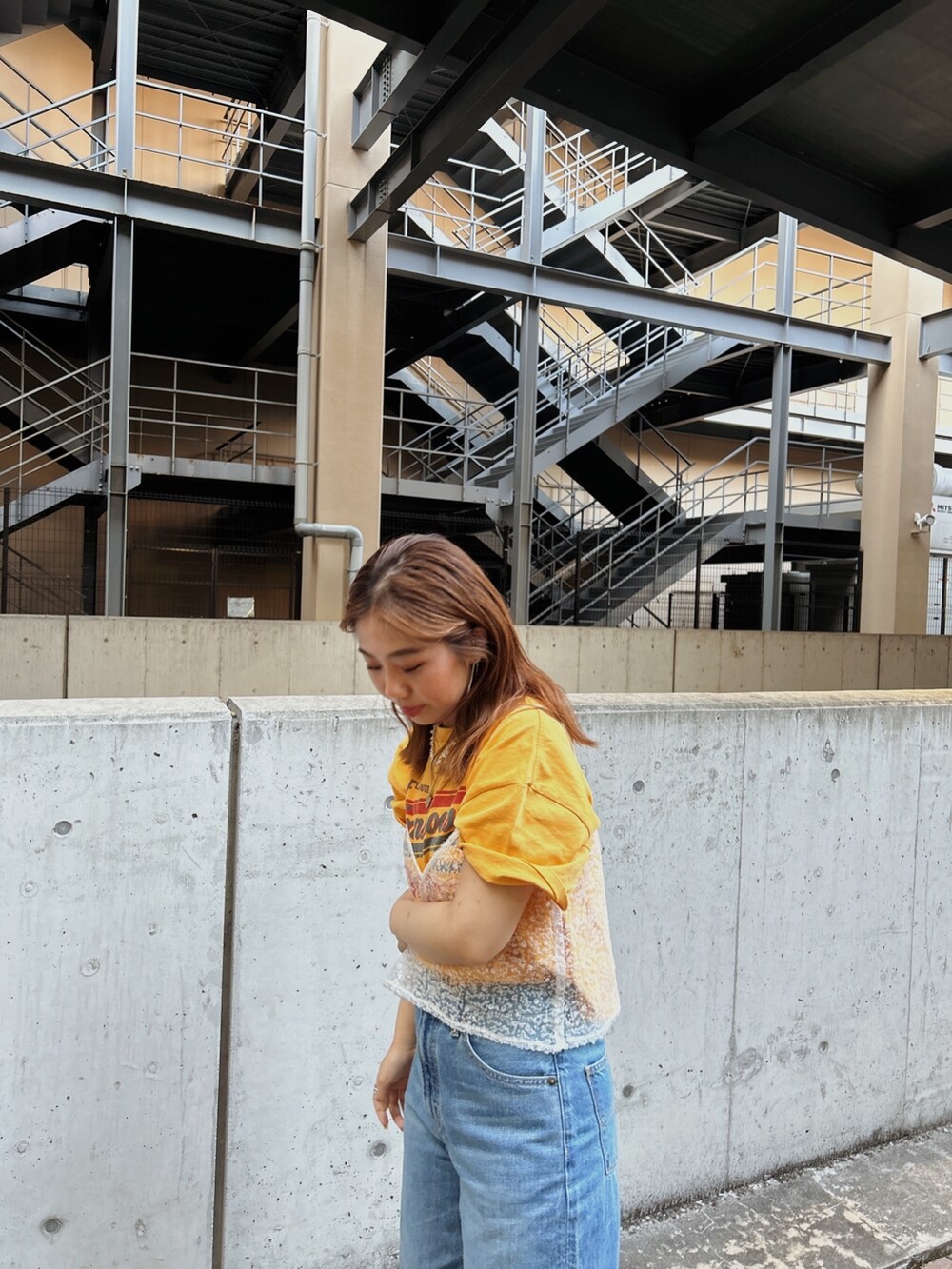 ホワイト系のキャミソール、イエロー系のTシャツ/カットソー、ブルー系のデニムパンツを着用したレディースの春コーディネートの4枚目の写真