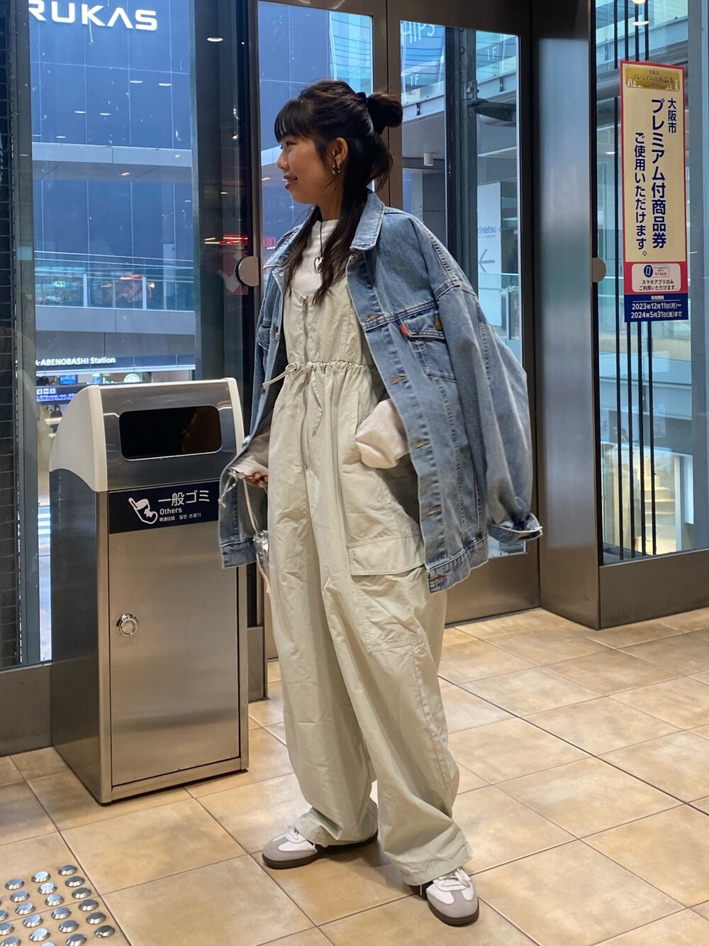 ブルー系のデニムジャケット、グレー系のサロペット/オーバーオール、ゴールド系のネックレスを着用したレディースの冬コーディネートの2枚目の写真