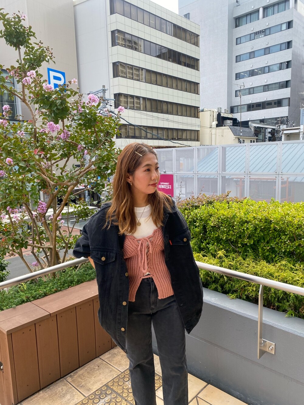 ブラック系のデニムジャケット、ブラック系のデニムパンツ、ピンク系のニット/セーターを着用したレディースの秋コーディネートの4枚目の写真