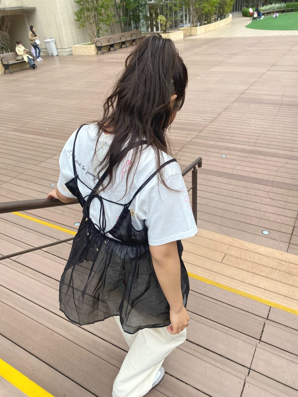 ホワイト系のTシャツ/カットソー、ブラック系のキャミソール、ホワイト系のデニムパンツを着用したレディースの春コーディネートの5枚目の写真