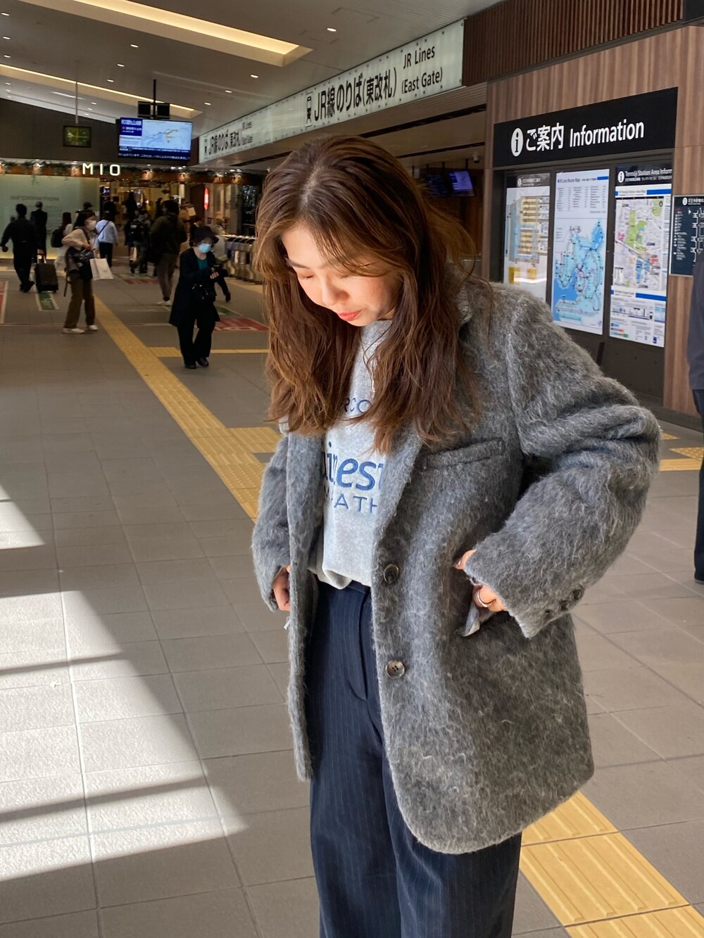 グレー系のテーラードジャケット、グレー系のニット/セーター、シルバー系のショルダーバッグを着用したレディースの冬コーディネートの5枚目の写真