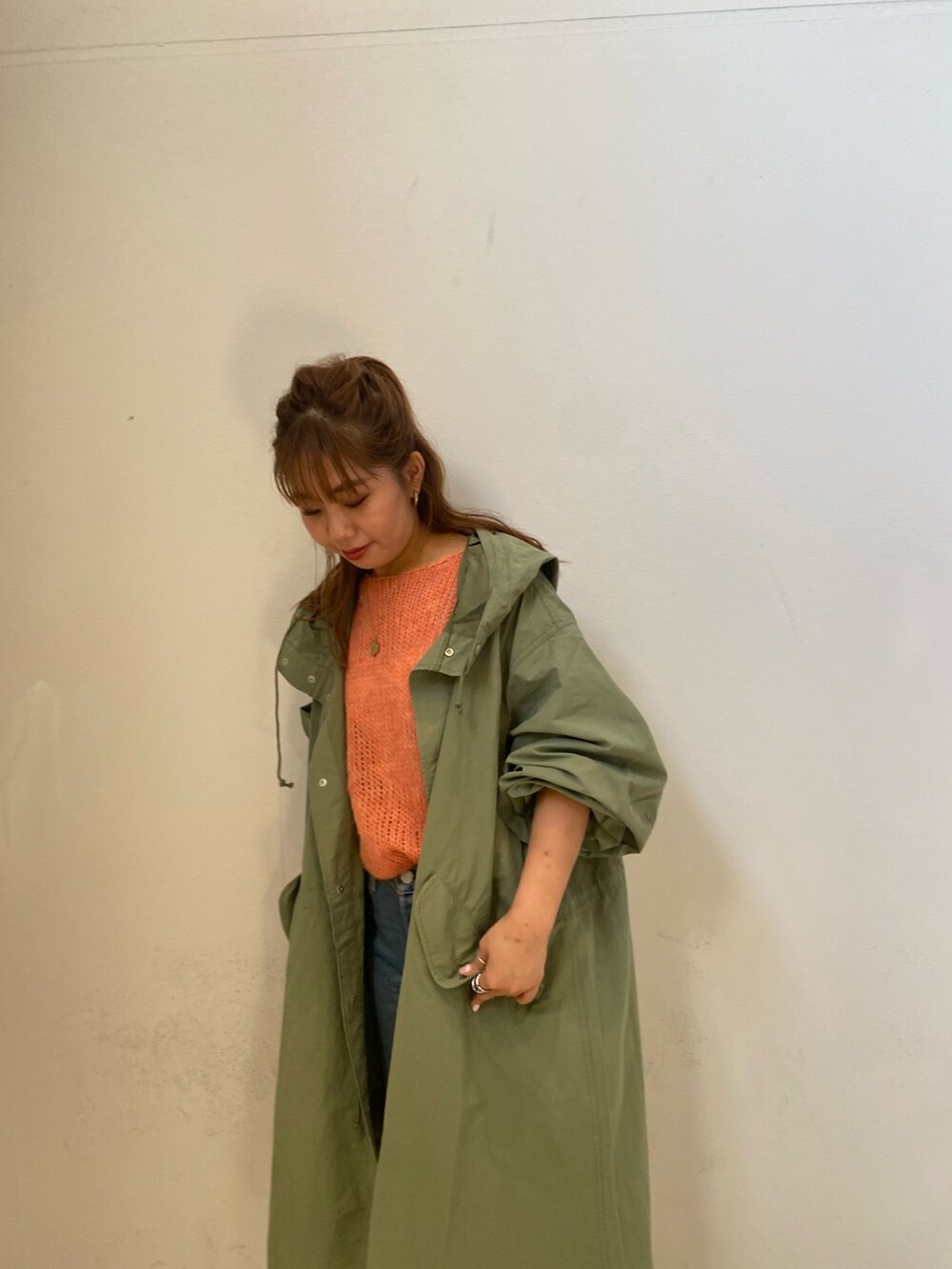 ピンク系のニット/セーター、グリーン系のブルゾン、ブルー系のデニムパンツを着用したレディースの秋コーディネートの5枚目の写真