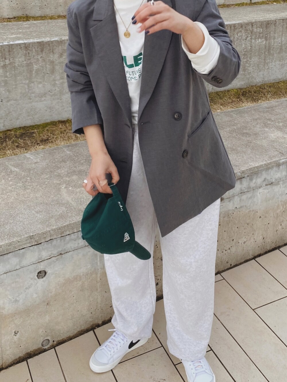 グレー系のテーラードジャケット、ホワイト系のTシャツ/カットソー、グレー系のスウェットパンツを着用したレディースの冬コーディネートの2枚目の写真