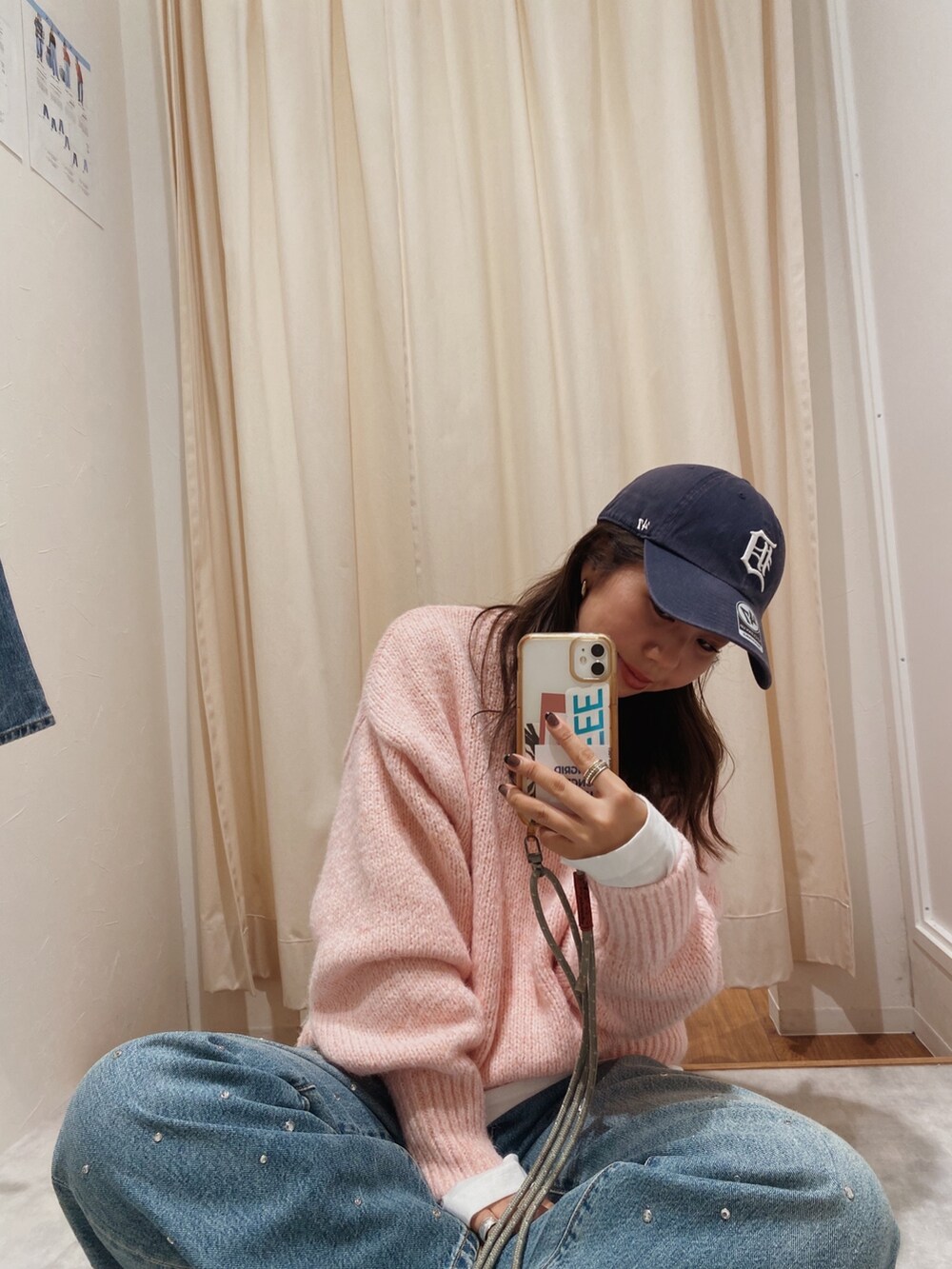 ピンク系のニット/セーター、ホワイト系のTシャツ/カットソー、ブルー系のデニムパンツを着用したレディースの秋コーディネートの2枚目の写真