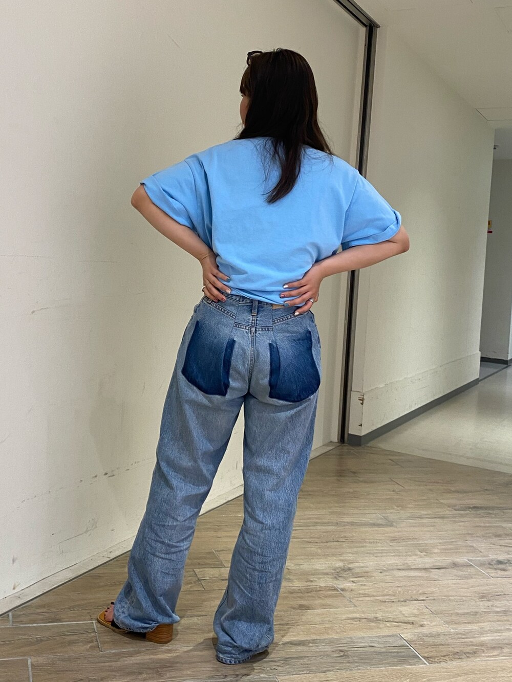 ブルー系のTシャツ/カットソー、ブルー系のデニムパンツ、ブラック系のサンダルを着用したレディースの春コーディネートの3枚目の写真