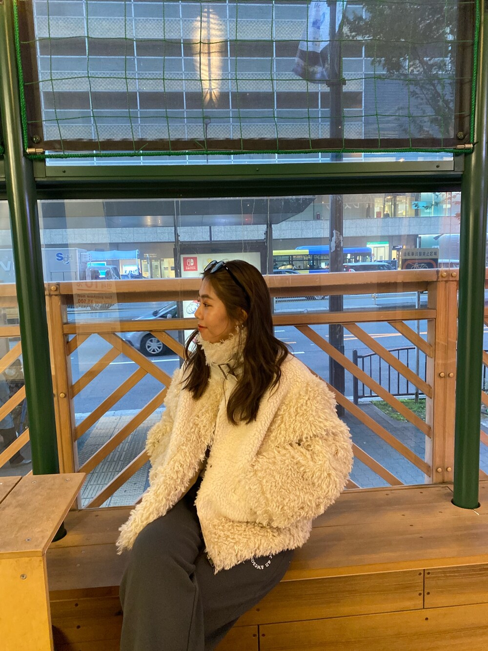 ホワイト系のムートンコート、グレー系のスウェットパンツを着用したレディースの冬コーディネートの5枚目の写真