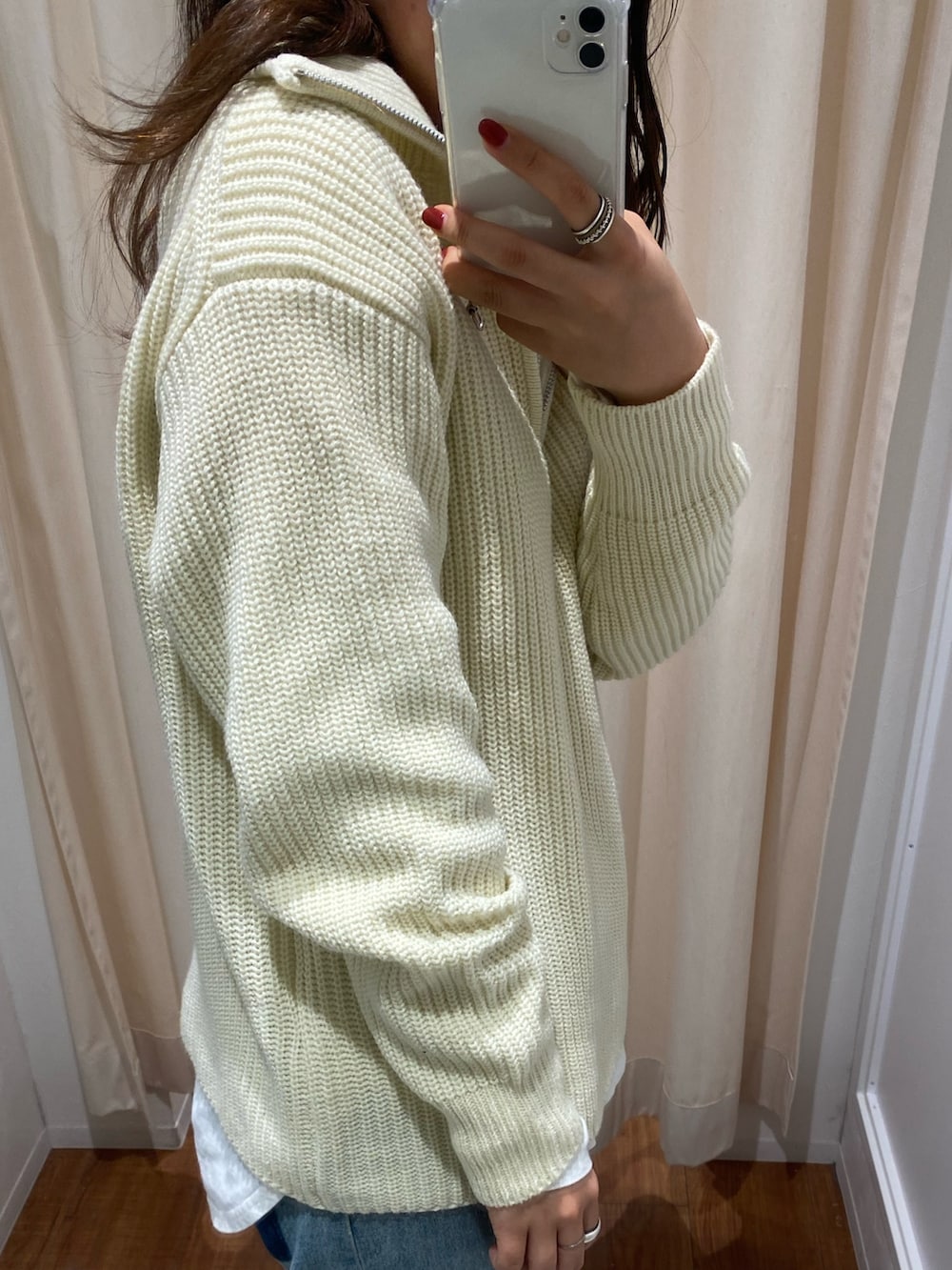 ホワイト系のニット/セーター、ブルー系のデニムパンツ、ホワイト系のTシャツ/カットソーを着用したレディースの冬コーディネートの4枚目の写真