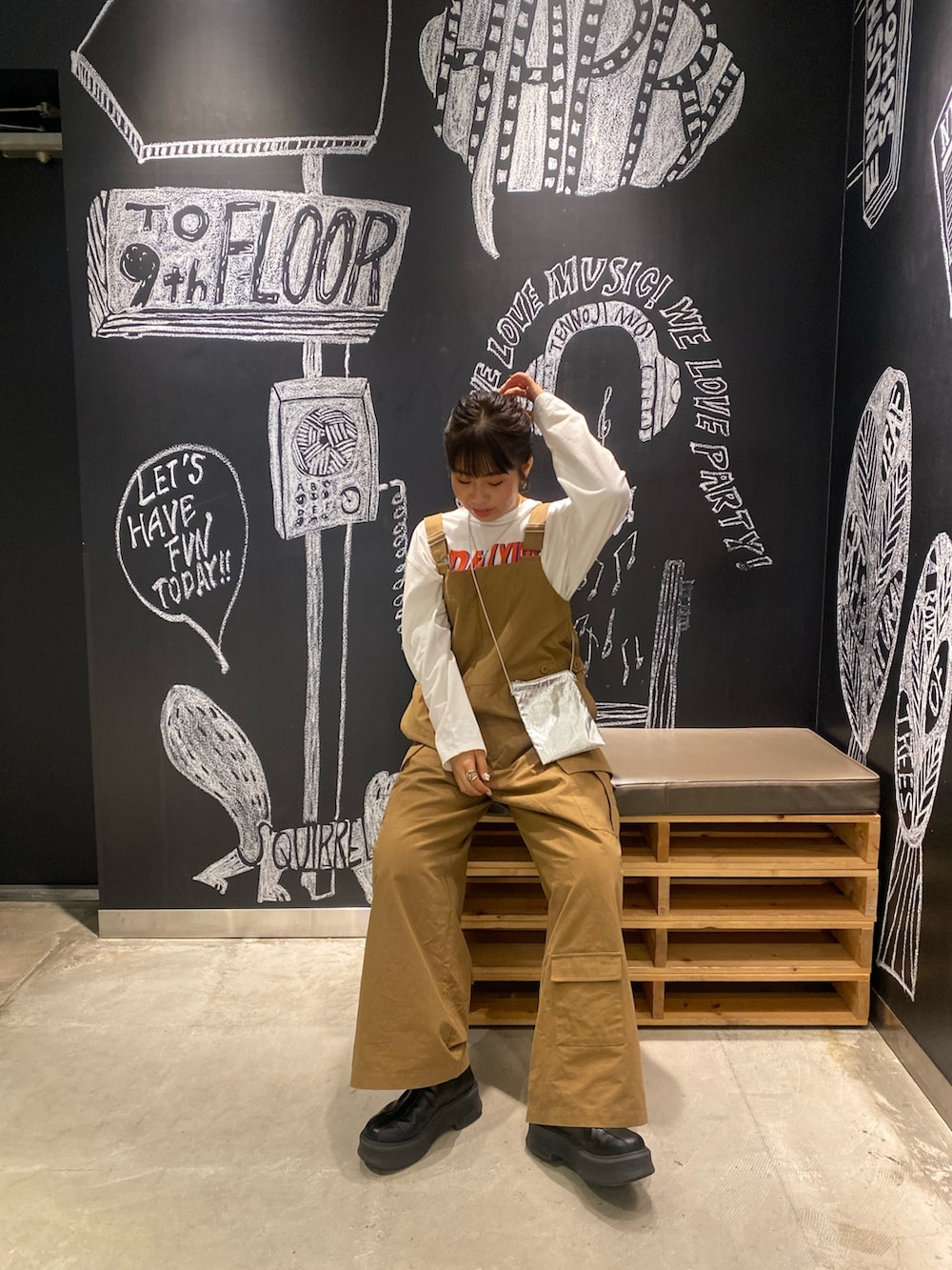 イエロー系のつなぎ/オールインワン、ホワイト系のTシャツ/カットソー、シルバー系のショルダーバッグを着用したレディースの冬コーディネートの4枚目の写真