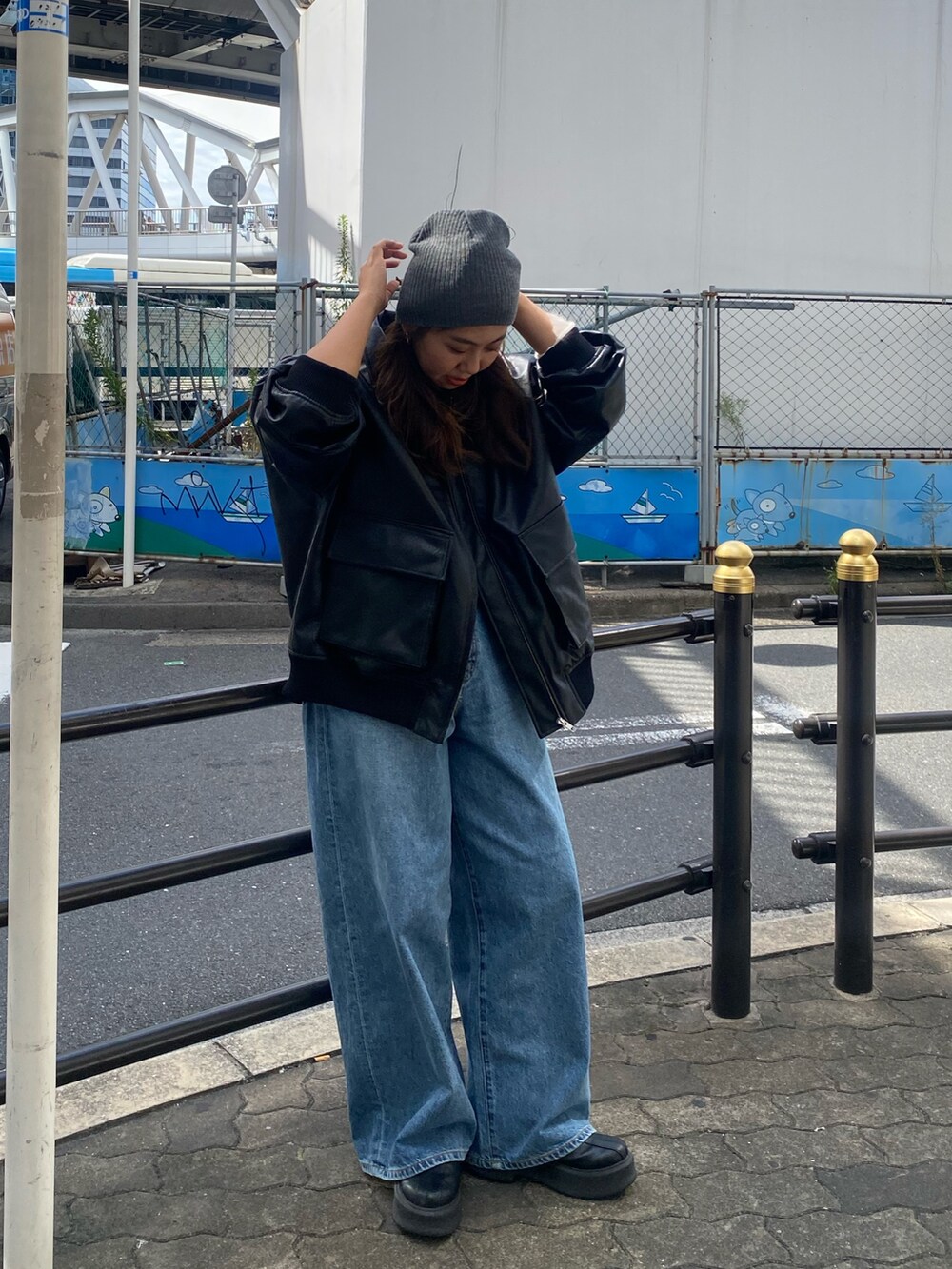 ホワイト系のニット/セーター、ブルー系のデニムパンツ、ブラック系のブルゾンを着用したレディースの秋コーディネートの5枚目の写真