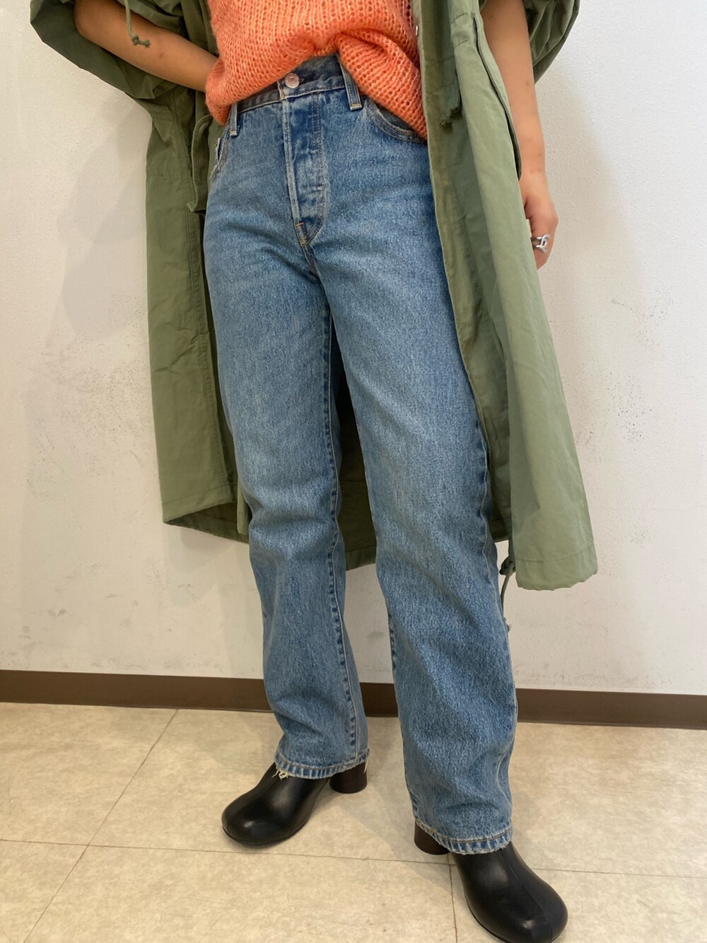 ピンク系のニット/セーター、グリーン系のブルゾン、ブルー系のデニムパンツを着用したレディースの秋コーディネートの7枚目の写真