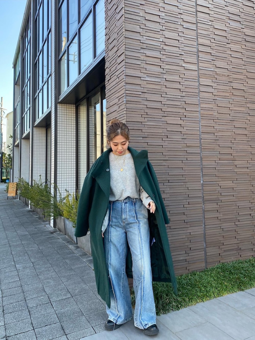 グリーン系のその他アウター、グレー系のニット/セーター、ブルー系のデニムパンツを着用したレディースの冬コーディネートの2枚目の写真