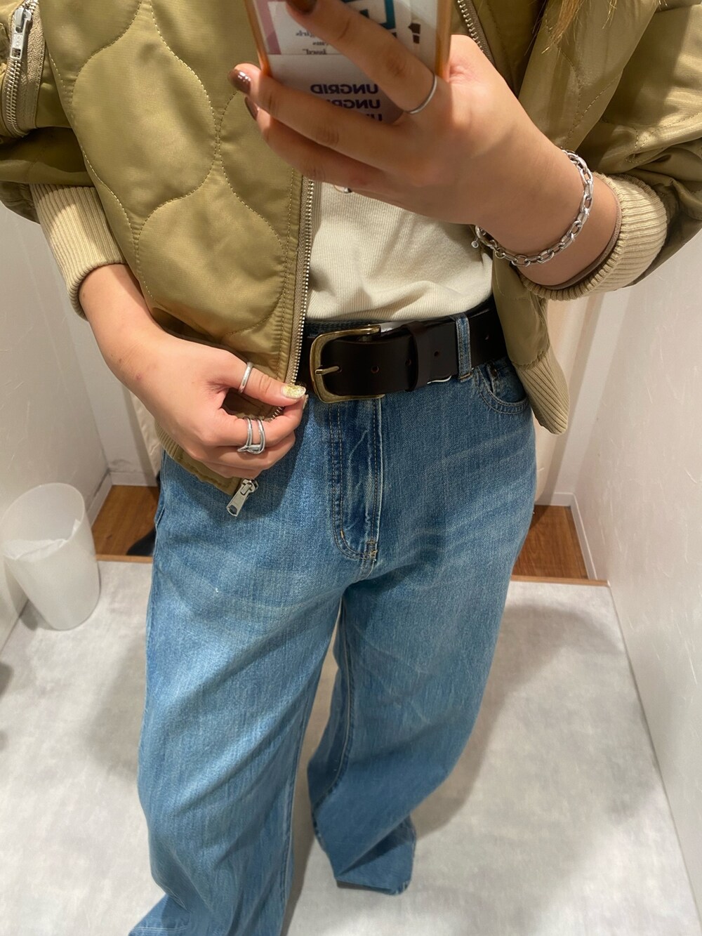 ベージュ系のブルゾン、ブルー系のデニムパンツ、ブラック系のブーツを着用したレディースの秋コーディネートの4枚目の写真