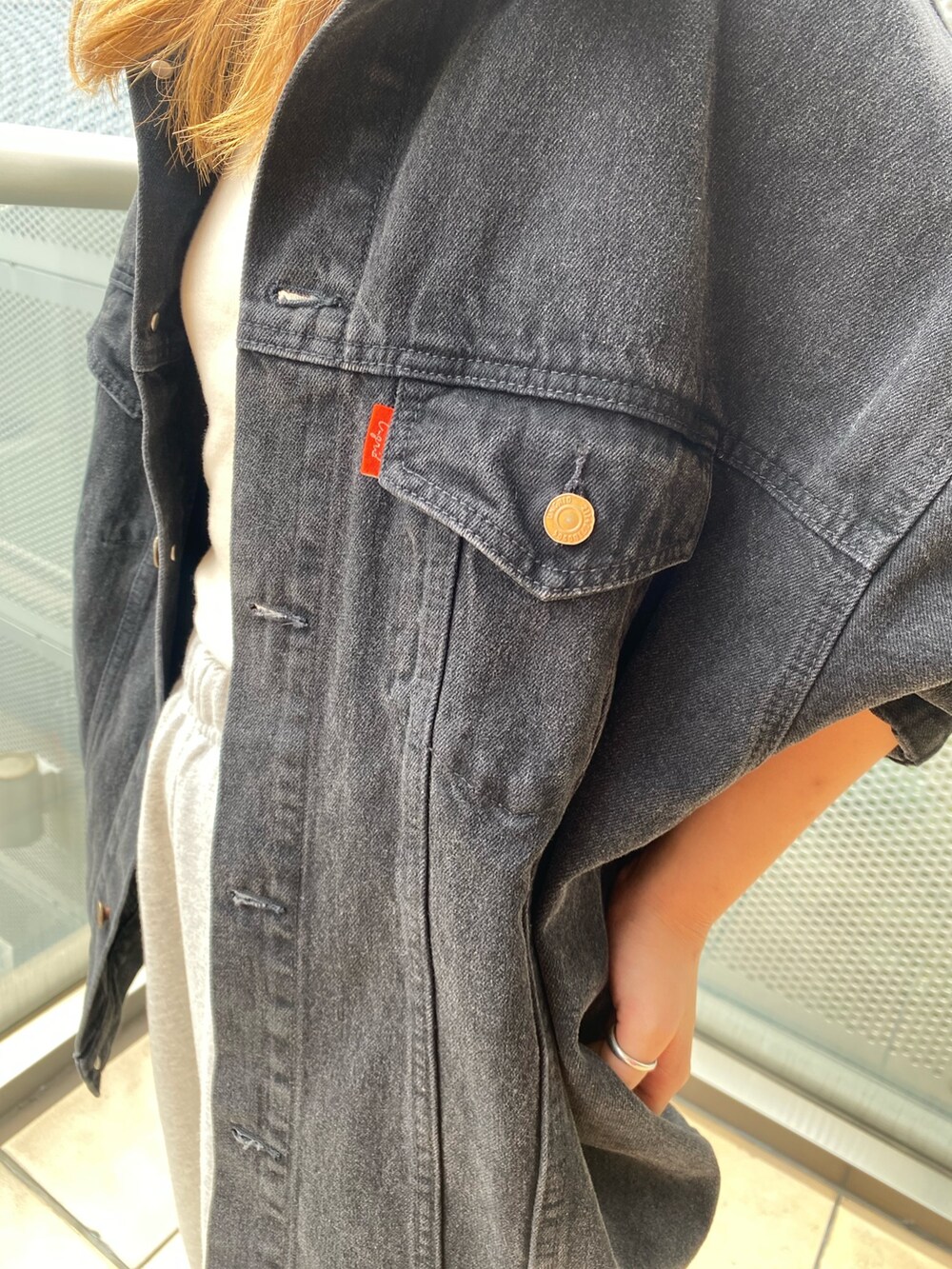 ブラック系のデニムジャケット、グレー系のスウェットパンツを着用したレディースの秋コーディネートの6枚目の写真