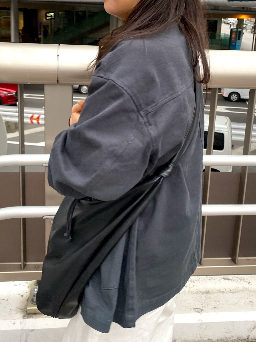 グレー系のブルゾン、ホワイト系のその他パンツ、ホワイト系のキャミソールを着用したレディースの春コーディネートの4枚目の写真