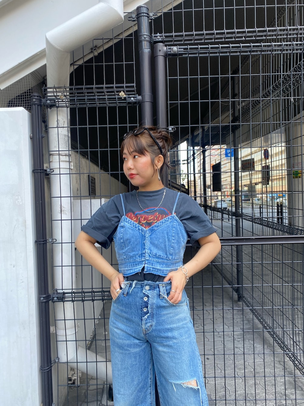 ブルー系のデニムパンツ、グレー系のTシャツ/カットソー、ブルー系のキャミソールを着用したレディースの春コーディネートの5枚目の写真