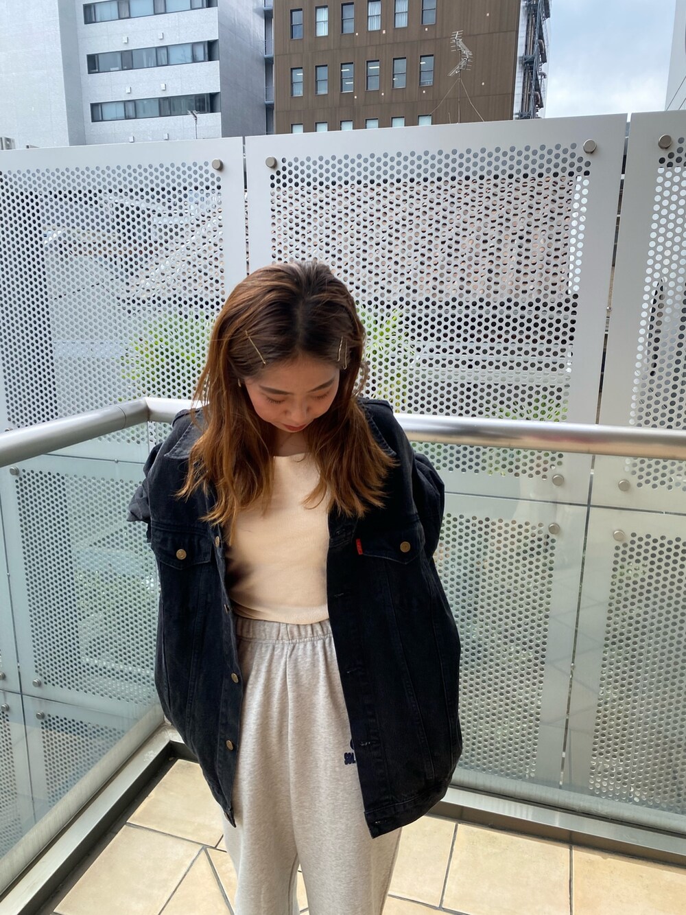 ブラック系のデニムジャケット、グレー系のスウェットパンツを着用したレディースの秋コーディネートの3枚目の写真