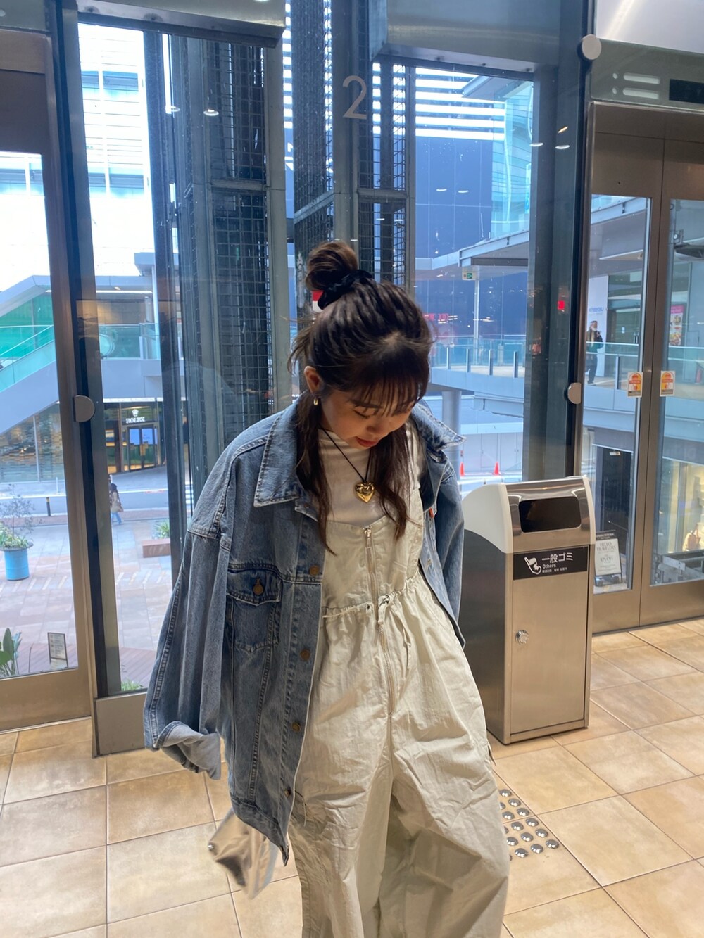 ブルー系のデニムジャケット、グレー系のサロペット/オーバーオール、ゴールド系のネックレスを着用したレディースの冬コーディネートの7枚目の写真