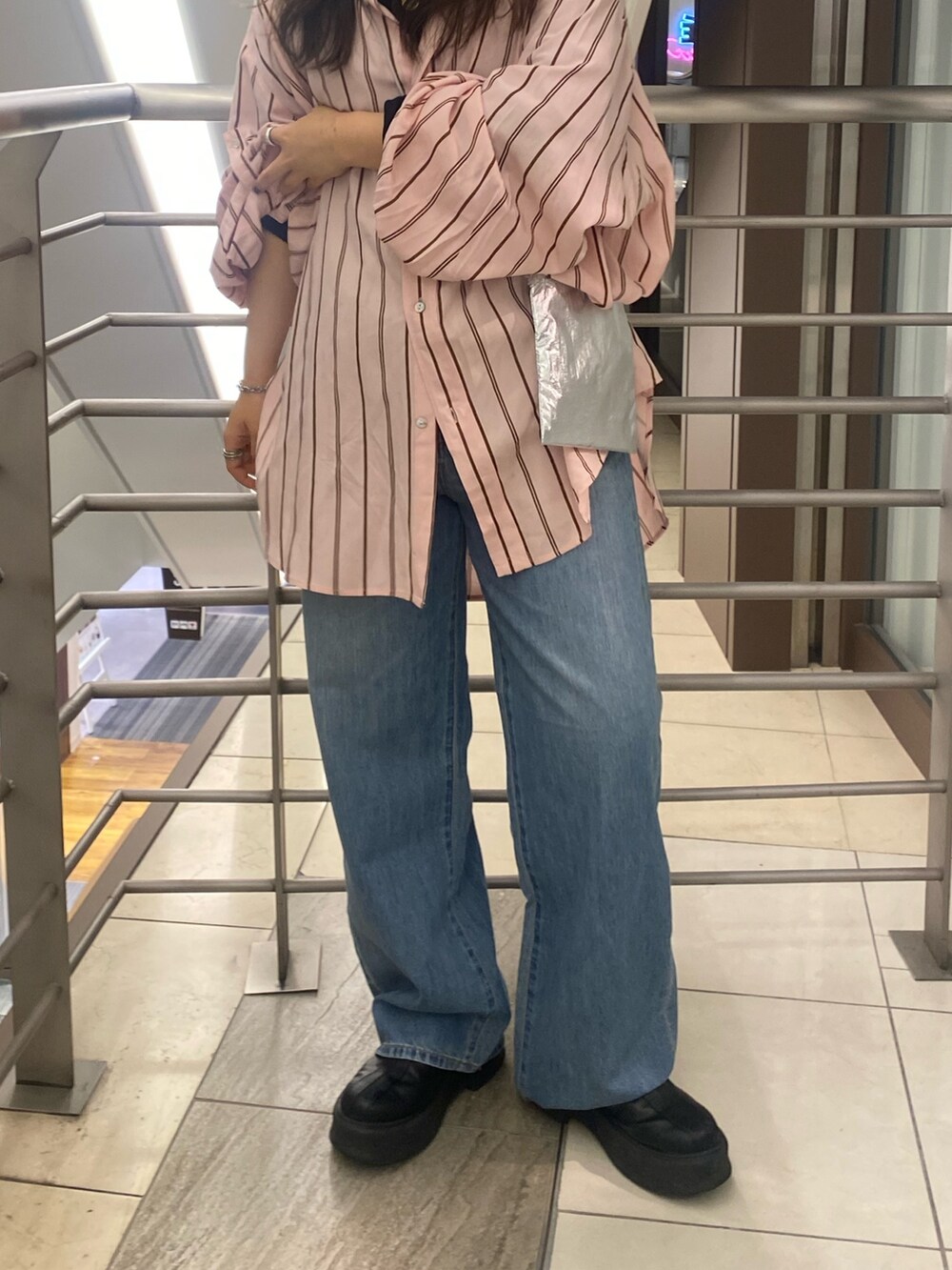 ピンク系のシャツ/ブラウス、ブルー系のデニムパンツ、シルバー系のショルダーバッグを着用したレディースの冬コーディネートの6枚目の写真