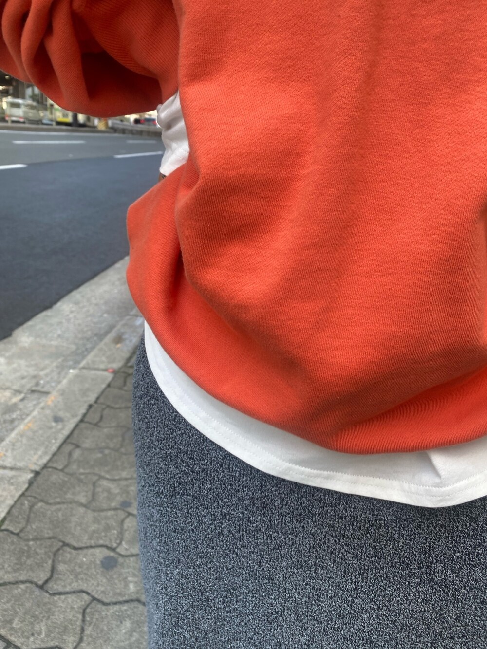 オレンジ系のスウェット、ホワイト系のTシャツ/カットソー、グレー系のスカートを着用したレディースの冬コーディネートの7枚目の写真