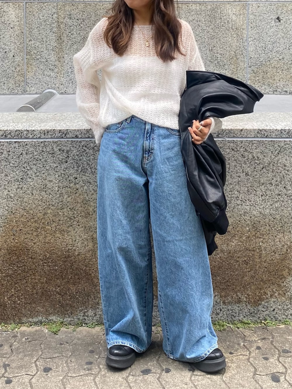 ホワイト系のニット/セーター、ブルー系のデニムパンツを着用したレディースの秋コーディネートの4枚目の写真