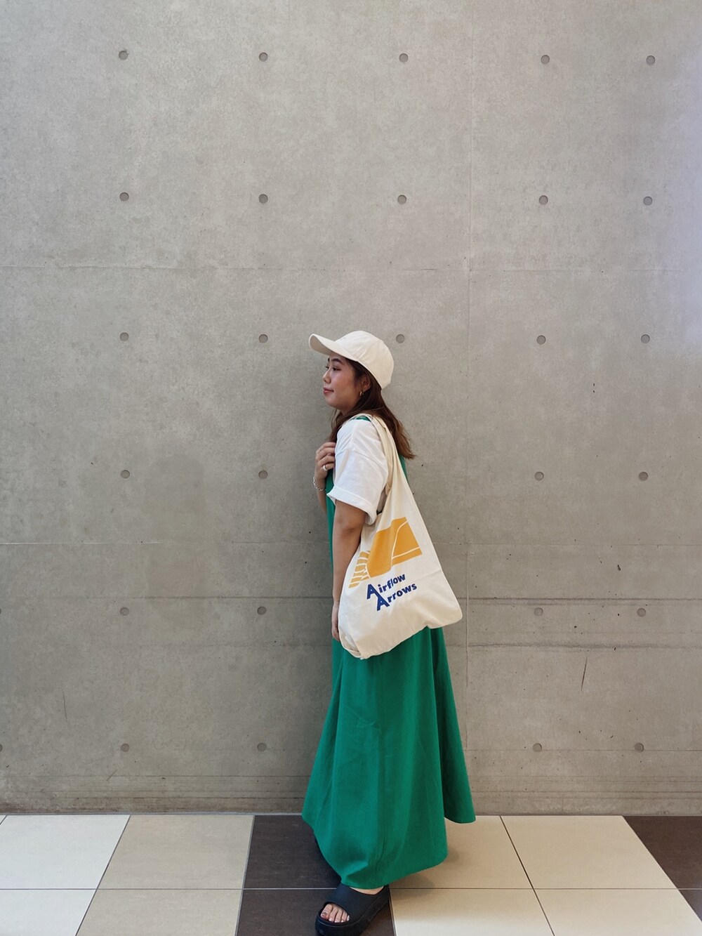 グリーン系のワンピース、ホワイト系のキャップを着用したレディースの夏コーディネートの3枚目の写真