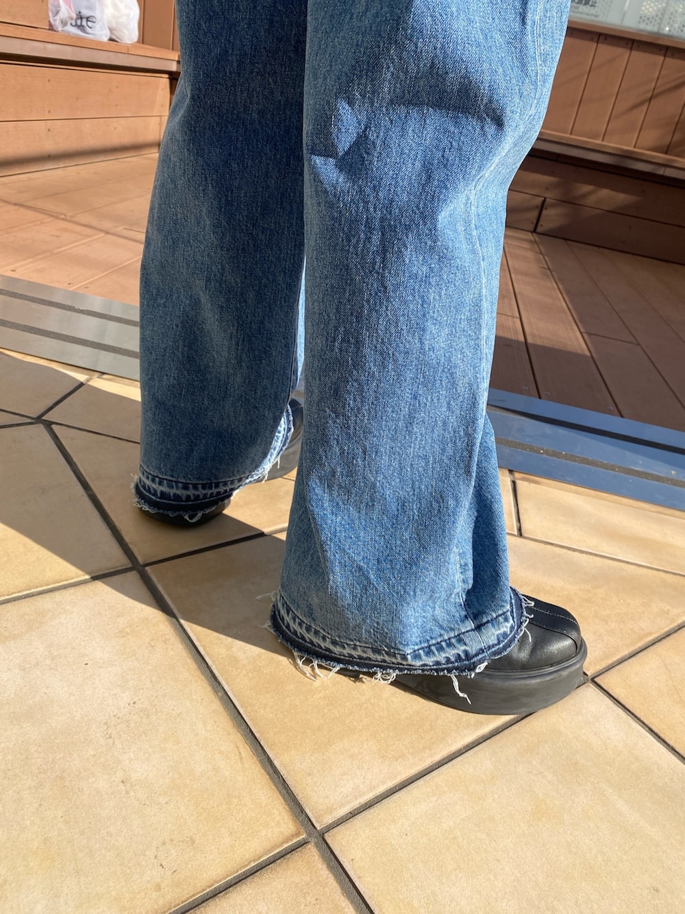 その他のチェスターコート、ブルー系のデニムパンツ、レッド系のニット/セーターを着用したレディースの冬コーディネートの7枚目の写真