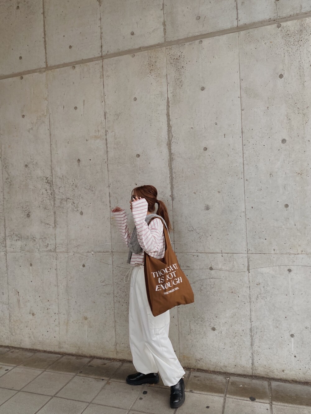 グレー系のニット/セーター、ブルー系のTシャツ/カットソー、ブルー系のエコバッグ/サブバッグを着用したレディースの冬コーディネートの2枚目の写真