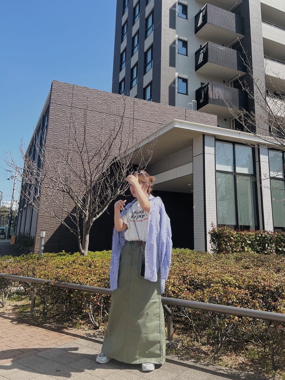 ホワイト系のTシャツ/カットソー、ブラック系のスカート、ブルー系のシャツ/ブラウスを着用したレディースの春コーディネートの2枚目の写真