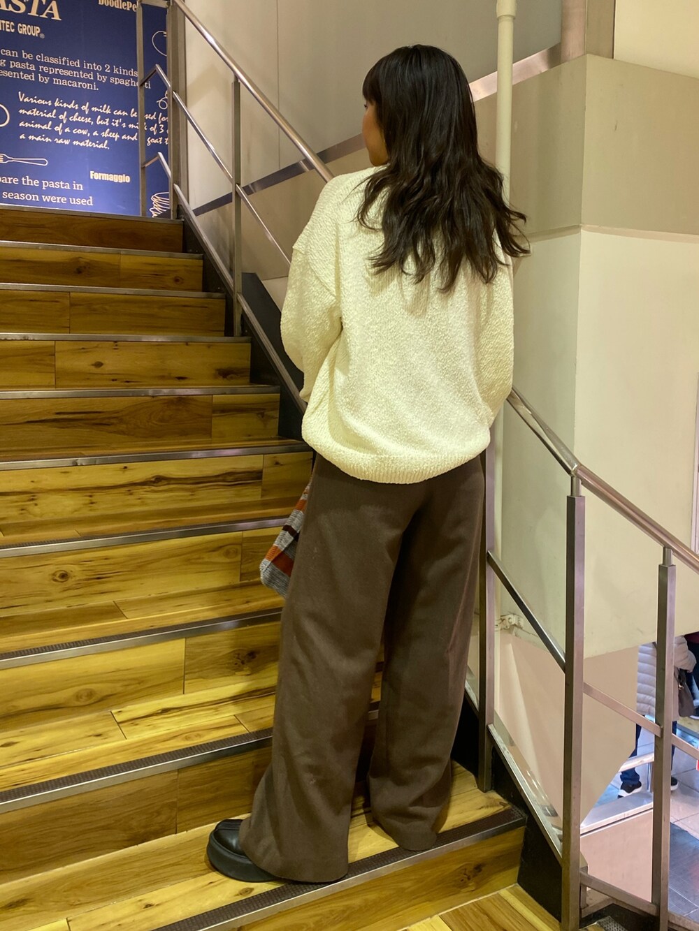 ホワイト系のニット/セーター、ブラウン系のその他パンツ、グレー系のハンドバッグを着用したレディースの冬コーディネートの2枚目の写真