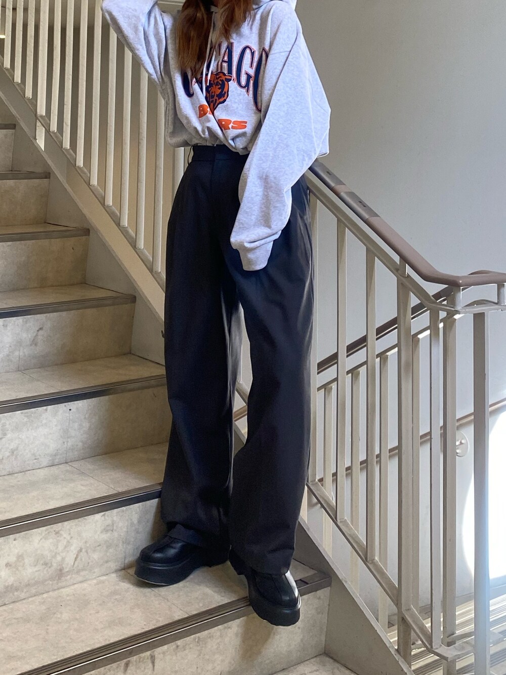 グレー系のパーカー、グレー系のその他パンツ、ブラック系のブーツを着用したレディースの秋コーディネートの5枚目の写真