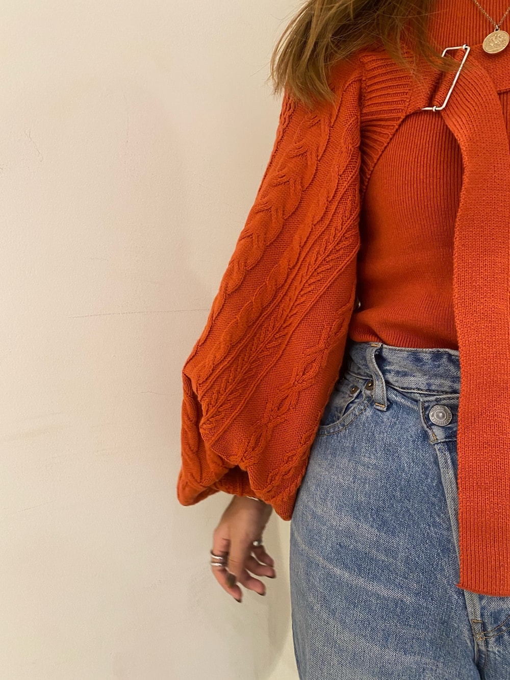 オレンジ系のカーディガン/ボレロ、ブルー系のデニムパンツ、ブラック系のブーツを着用したレディースの秋コーディネートの6枚目の写真