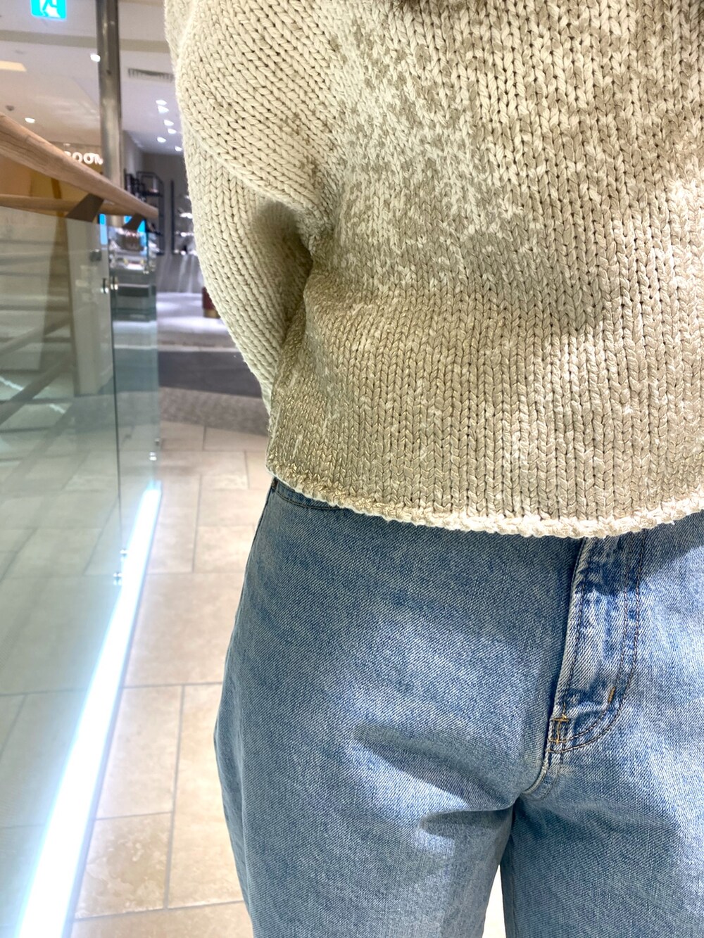 ホワイト系のニット/セーター、ブルー系のデニムパンツ、ブラウン系のショルダーバッグを着用したレディースの冬コーディネートの5枚目の写真