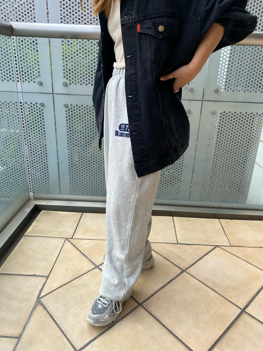 ブラック系のデニムジャケット、グレー系のスウェットパンツを着用したレディースの秋コーディネートの5枚目の写真