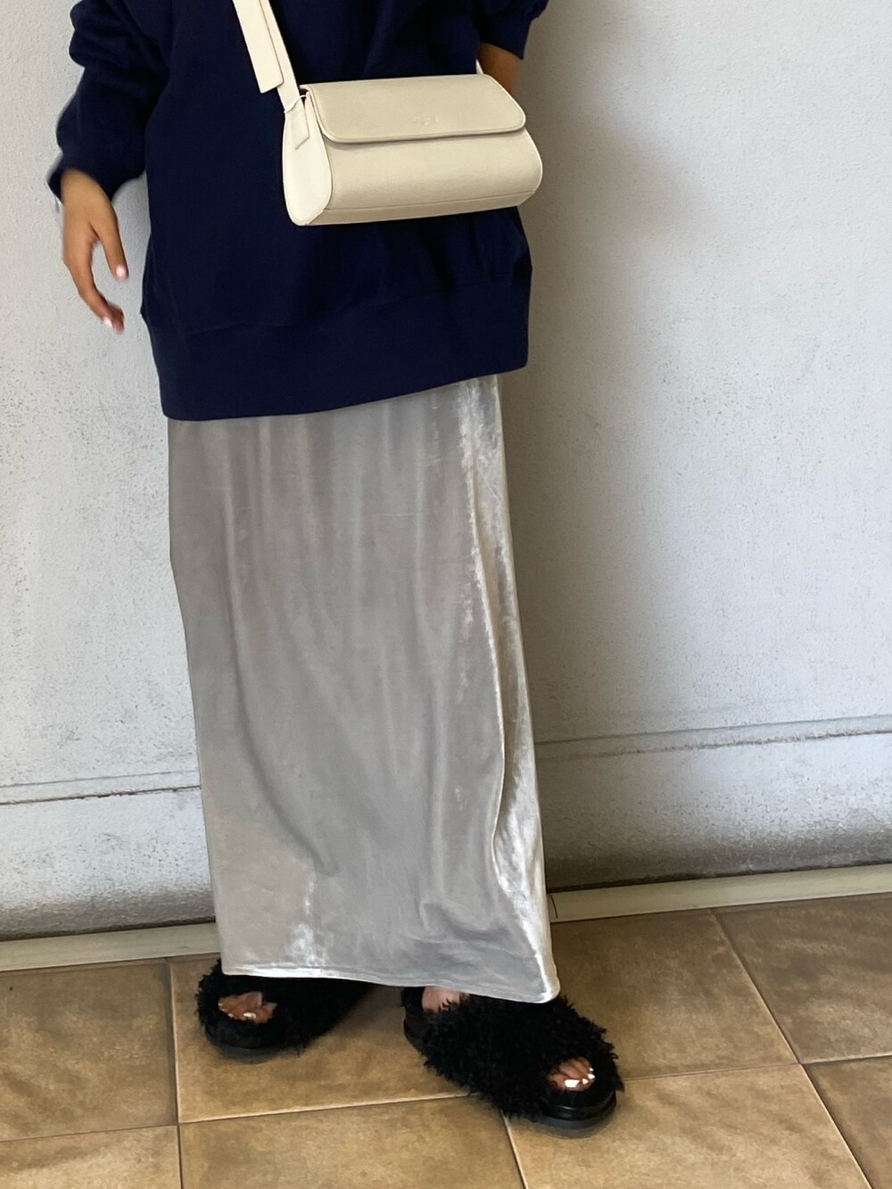 ブルー系のスウェット、グレー系のスカート、ホワイト系のショルダーバッグを着用したレディースの秋コーディネートの5枚目の写真