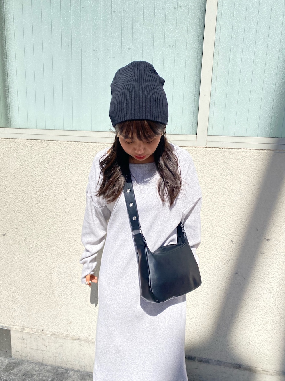 グレー系のワンピース、ブラック系のショルダーバッグを着用したレディースの冬コーディネートの4枚目の写真