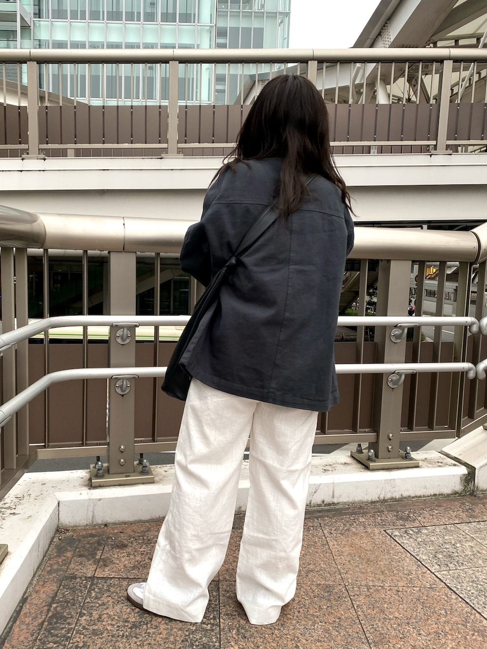 グレー系のブルゾン、ホワイト系のその他パンツ、ホワイト系のキャミソールを着用したレディースの春コーディネートの3枚目の写真